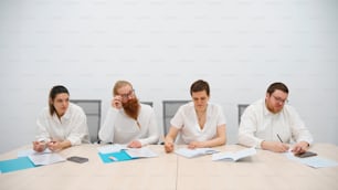 a group of people sitting around a wooden table