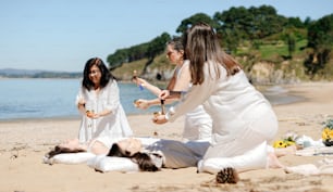 모래 해변 위에 앉아있는 한 무리의 여성들