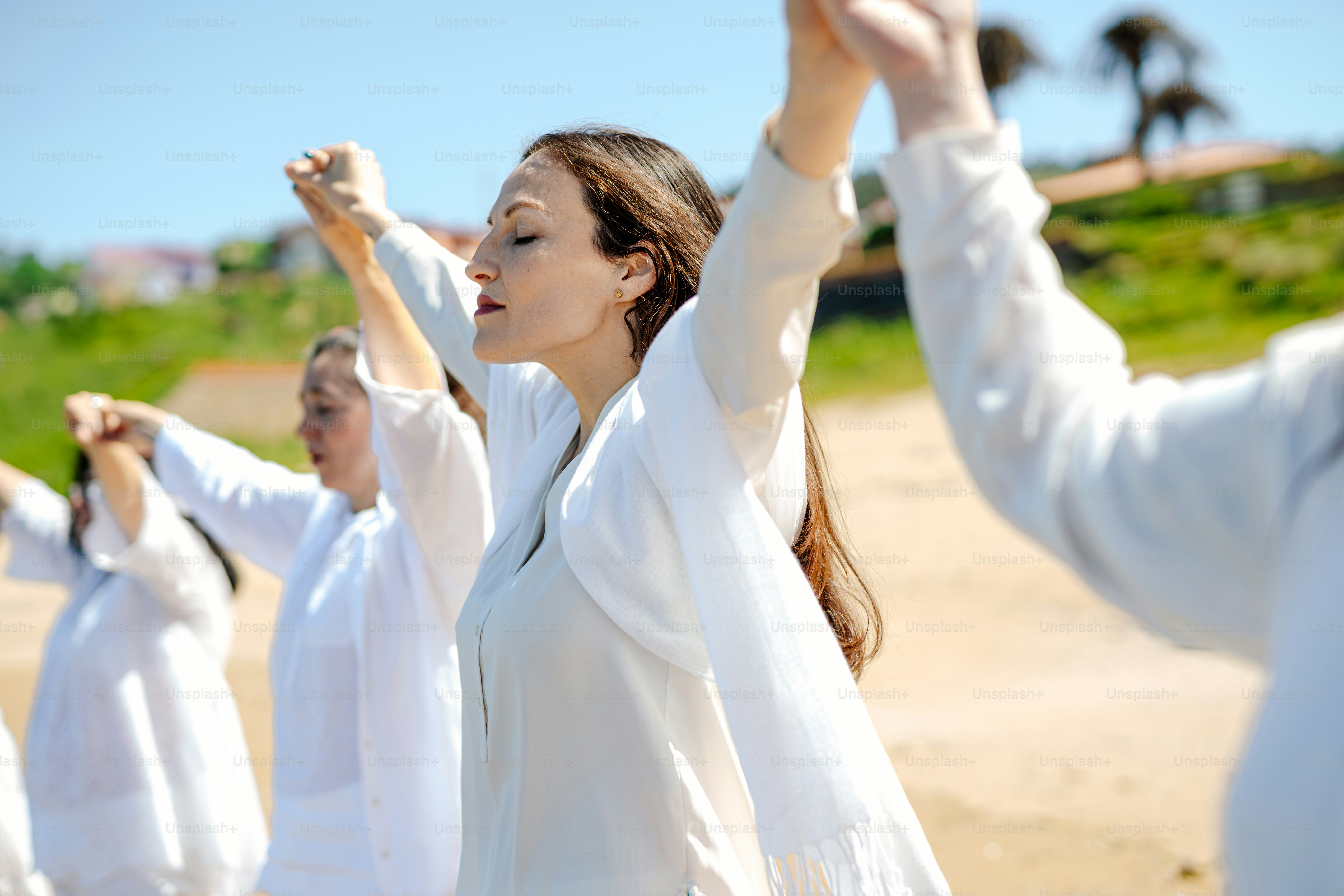 a group of women standing on top of a sandy beach