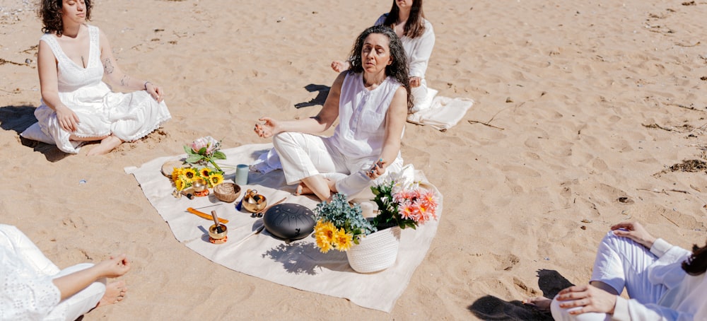 un grupo de mujeres sentadas en la cima de una playa de arena