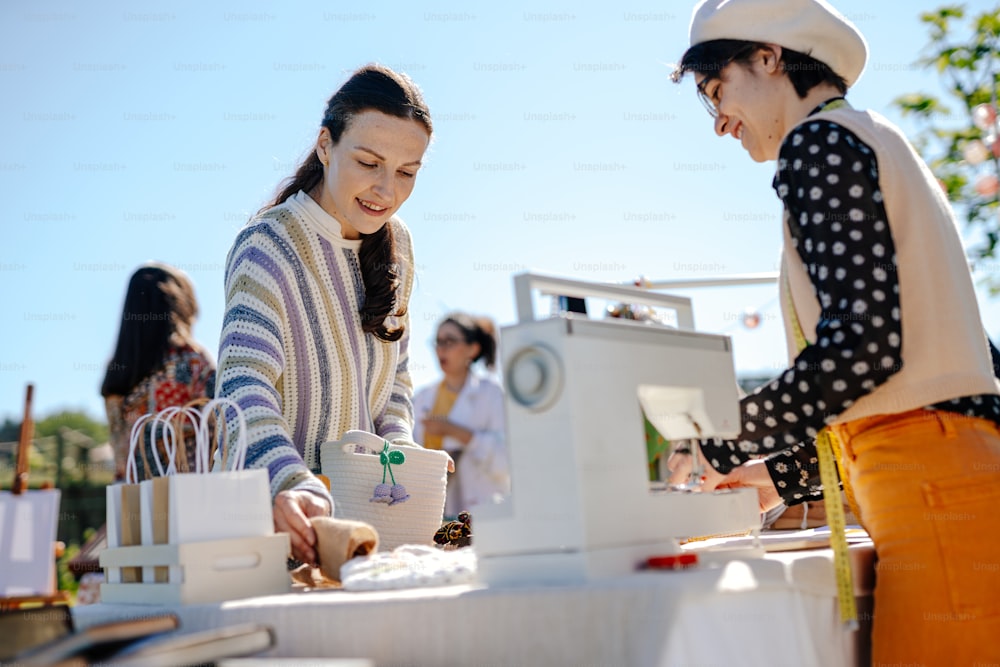 a couple of women standing next to each other at a table