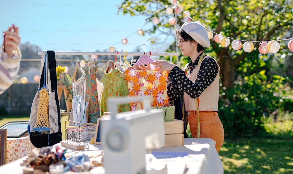 a woman standing next to a table filled with bags