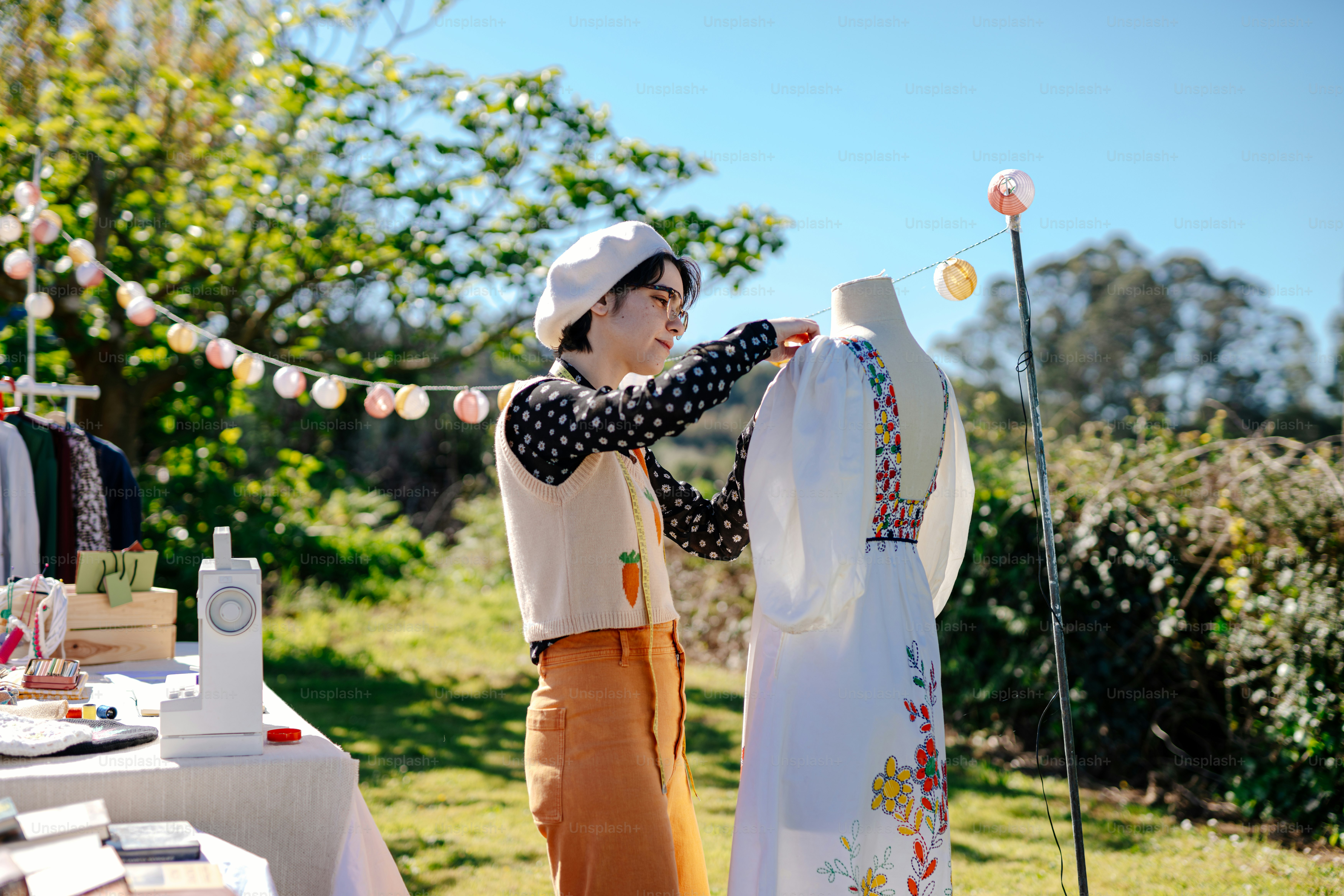 a woman standing next to a table with a dress on it