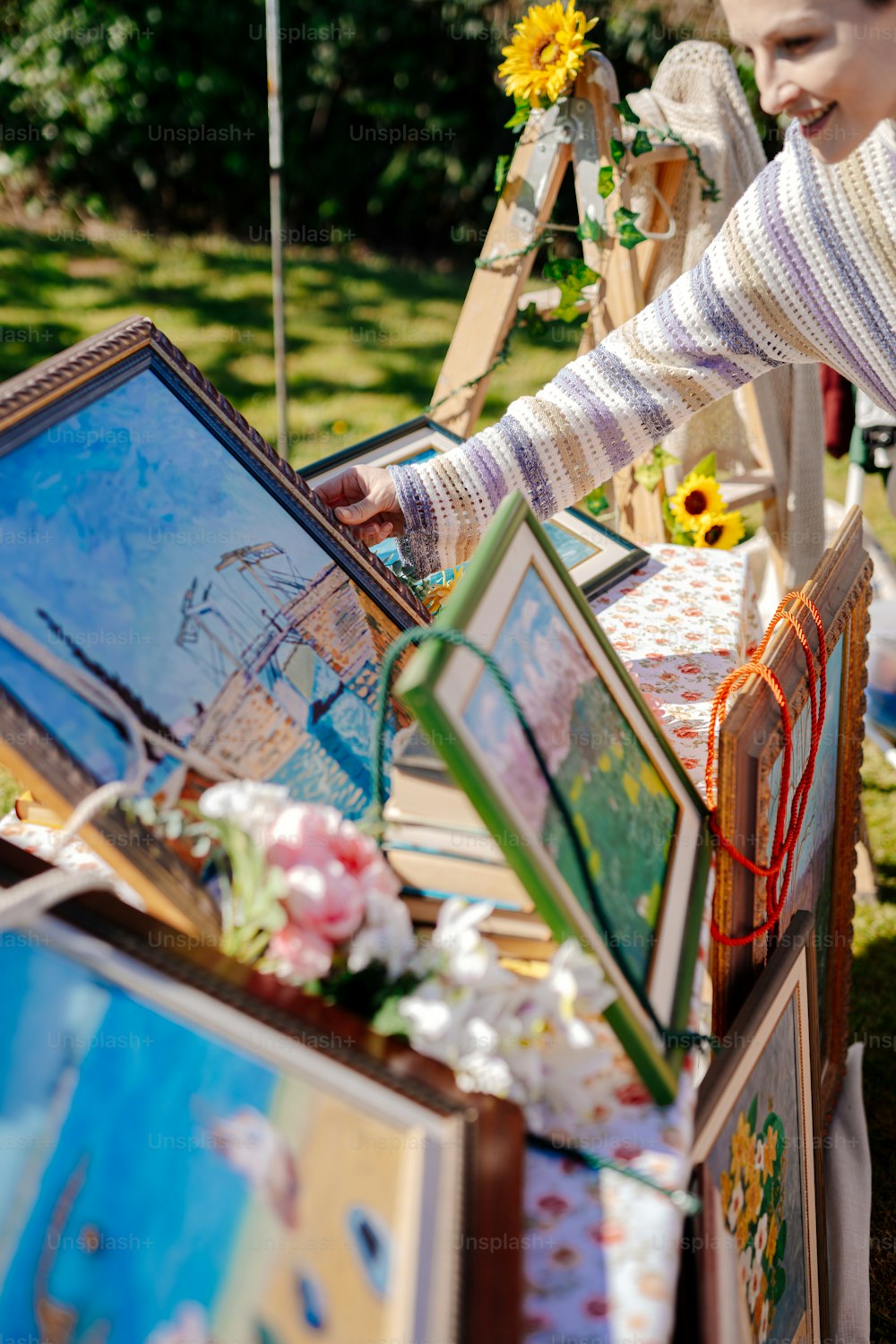 a woman standing next to a table with pictures on it