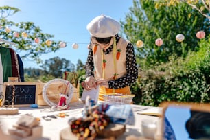 요리사 모자를 쓴 여성이 테이블 위에 음식을 준비하고 있다