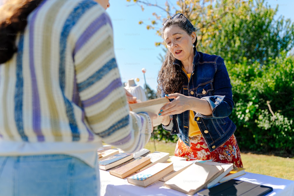 a woman standing at a table in front of another woman