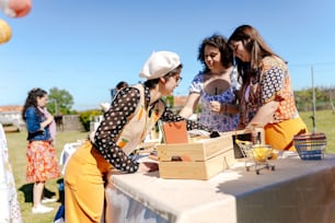 a group of women standing around a table