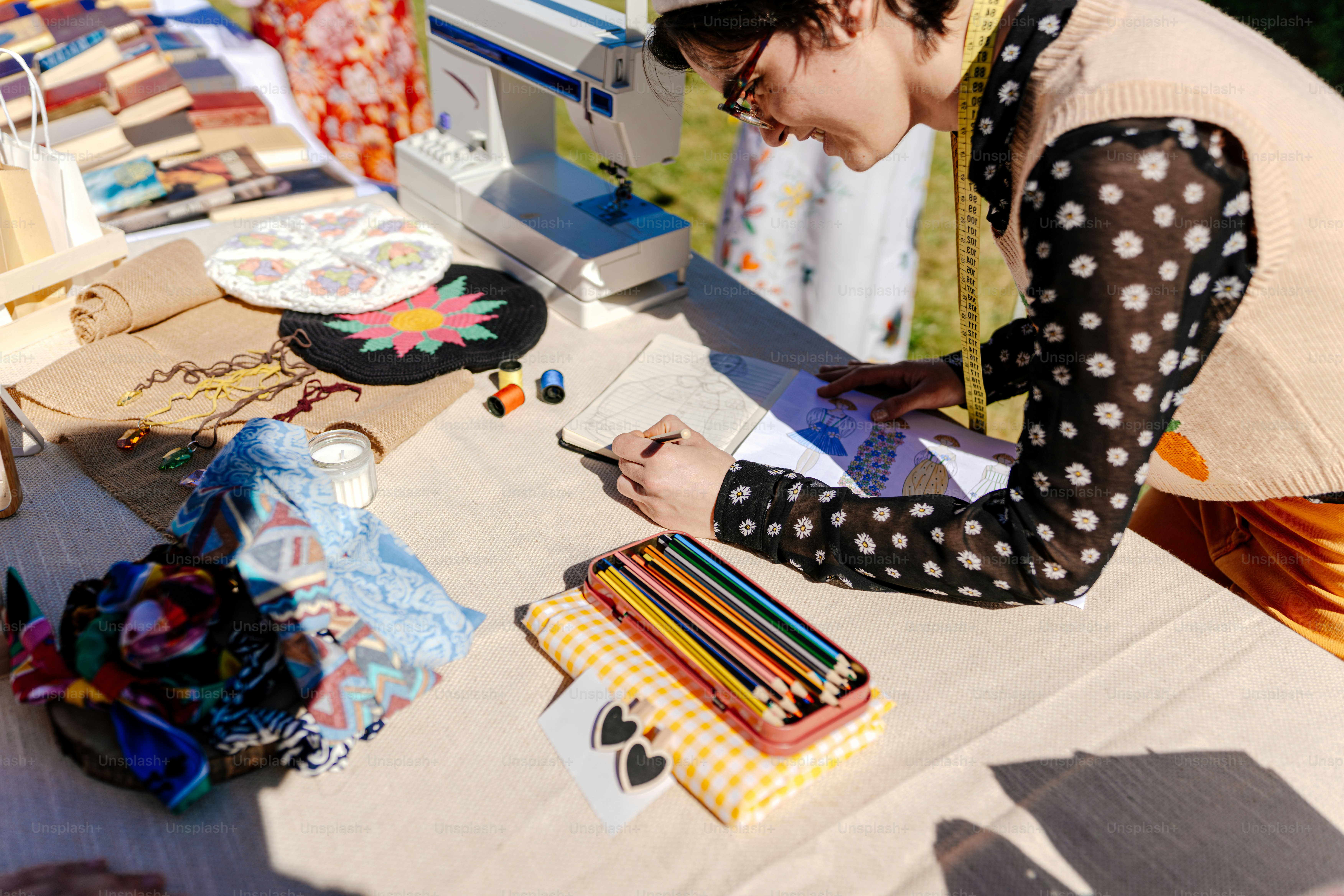 a woman sitting at a table with a sewing machine