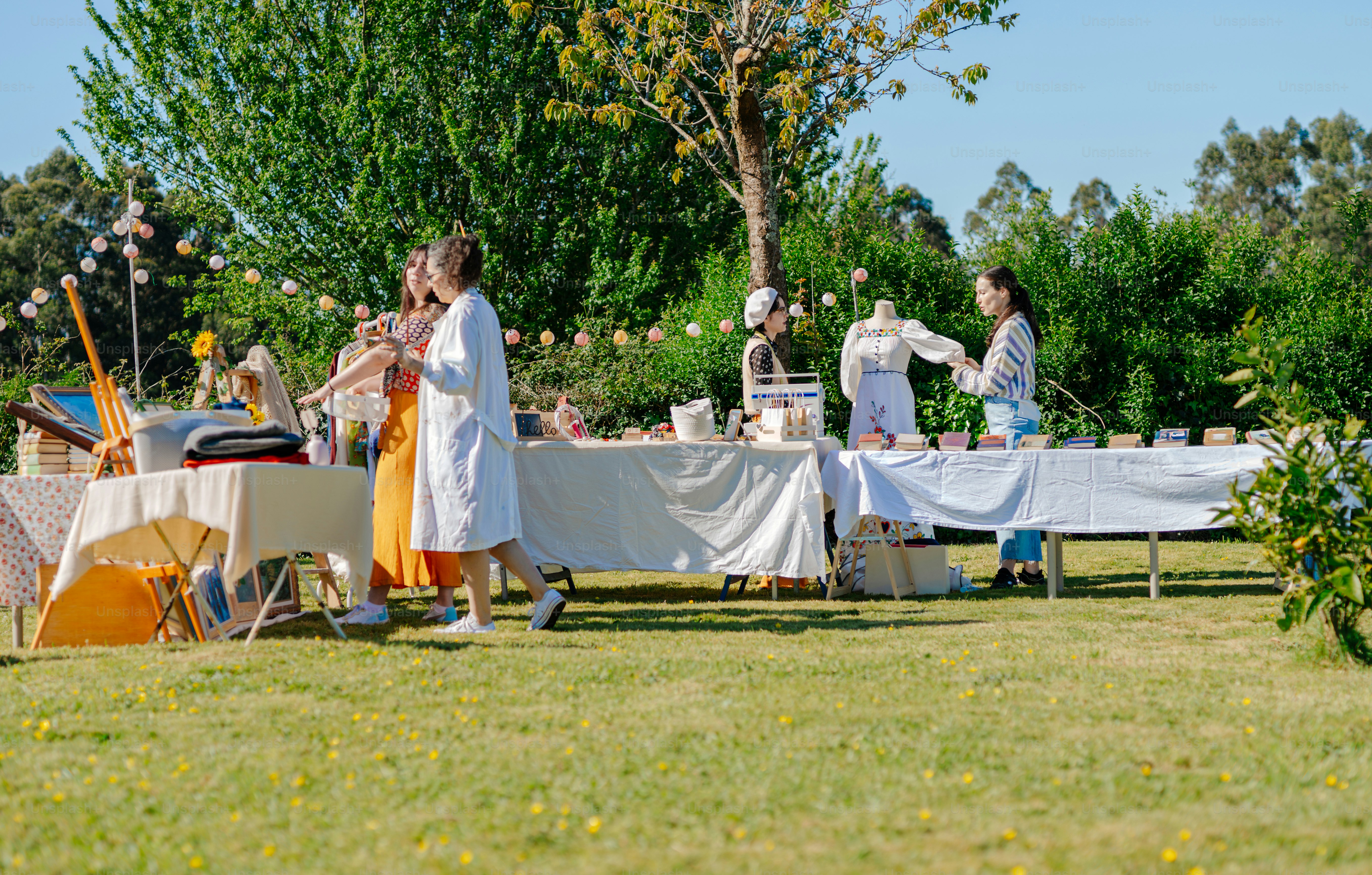 A group of people standing around a table covered in white cloths photo ...