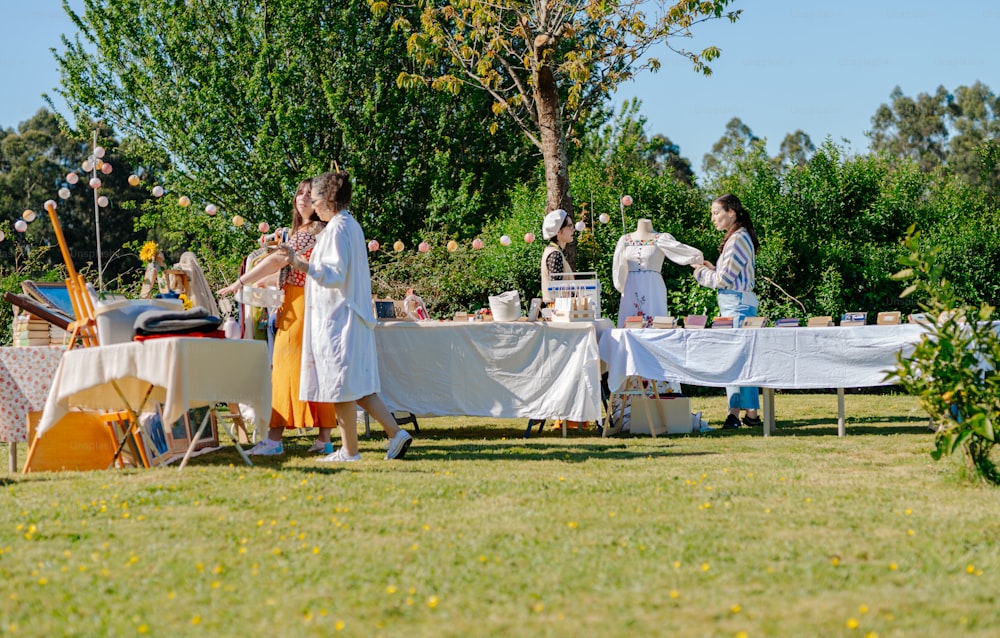 Un grupo de personas de pie alrededor de una mesa cubierta con manteles blancos