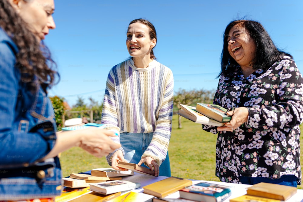 a group of women standing around a table filled with books