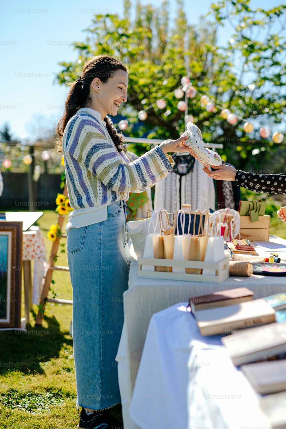 a woman is handing a cake to another woman