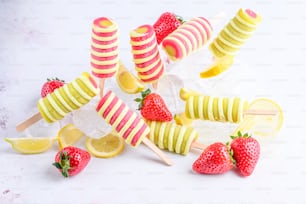 a group of popsicles with strawberries and lemon slices