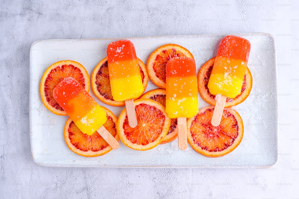 a white plate topped with orange slices and pops