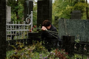 a woman sitting on a bench in a cemetery