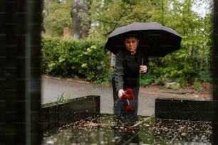 a woman holding a black umbrella over her head