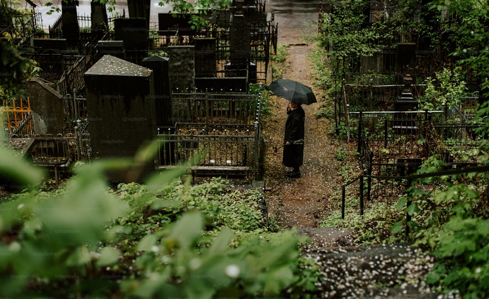 eine Frau mit einem Regenschirm steht in einem Garten