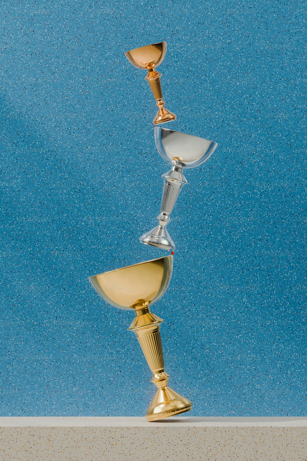 una copa de oro y una copa de plata sobre una mesa