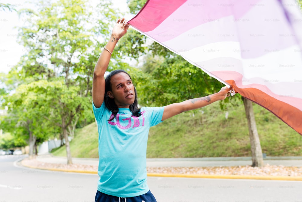 una mujer sosteniendo una gran bandera rosa y blanca
