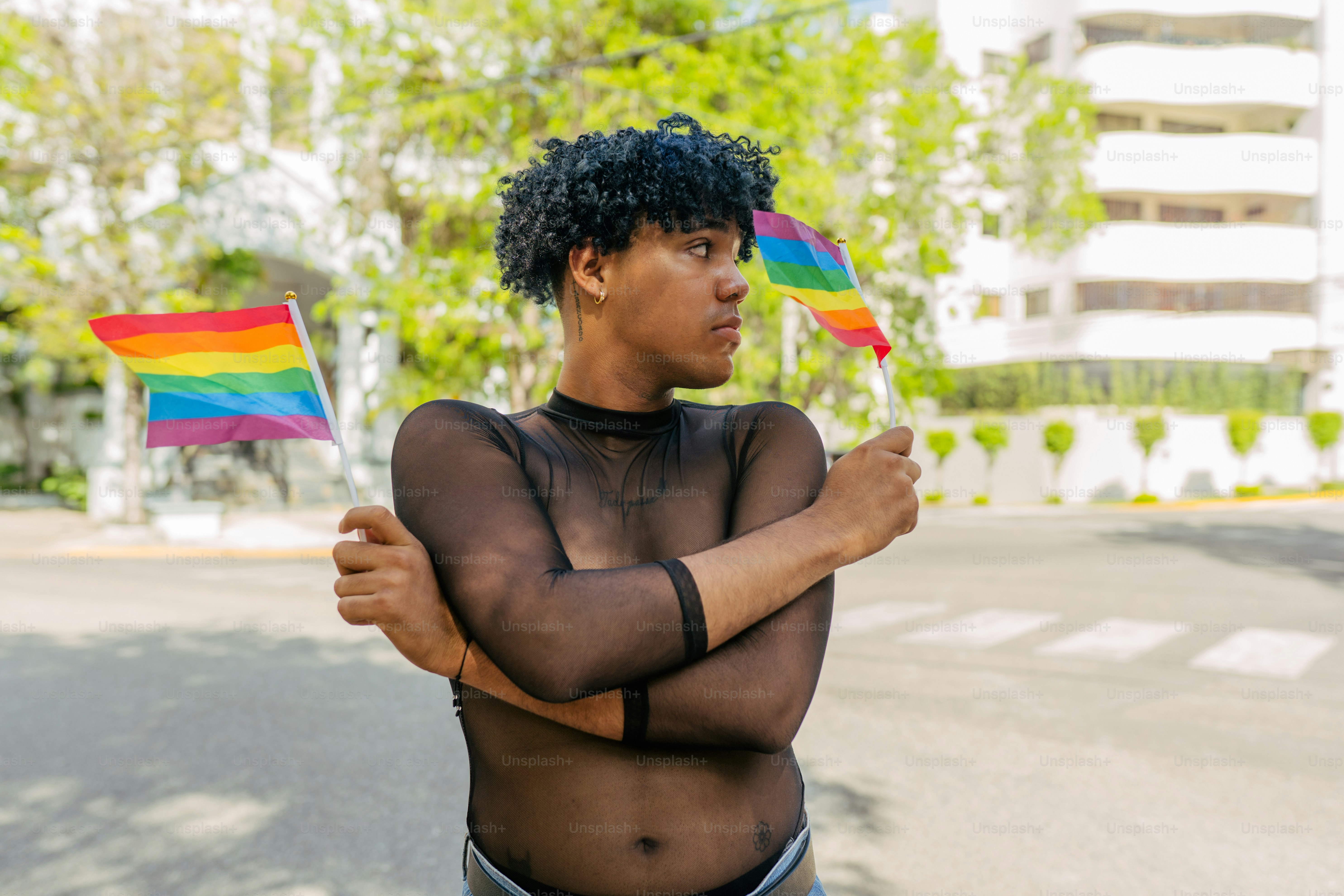 a woman holding a rainbow flag in the street