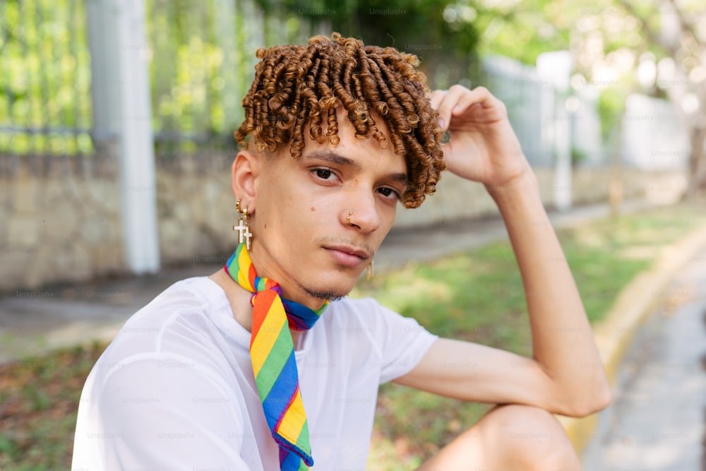 a young man with dreadlocks sitting on the ground