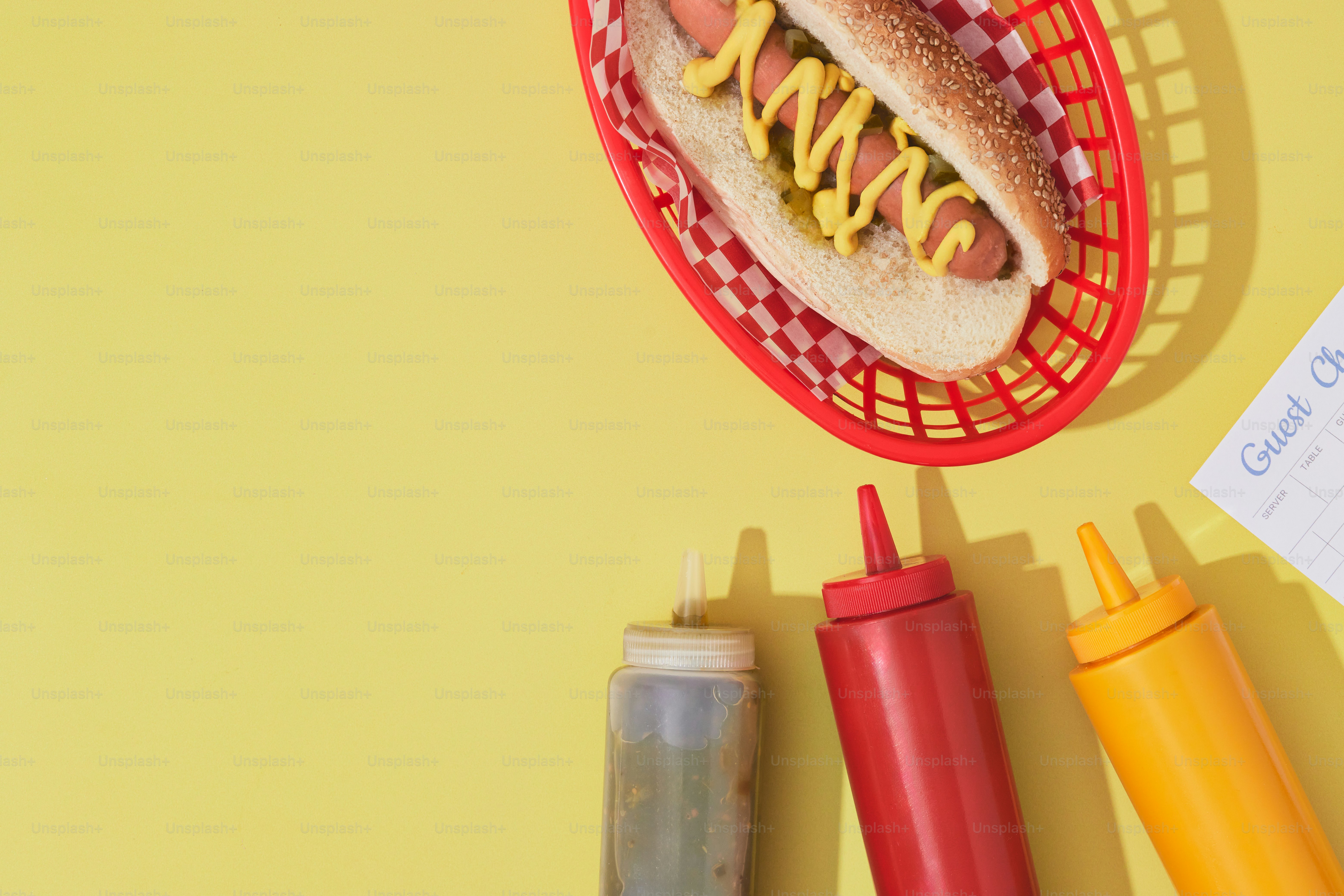 a hot dog in a basket with mustard and ketchup