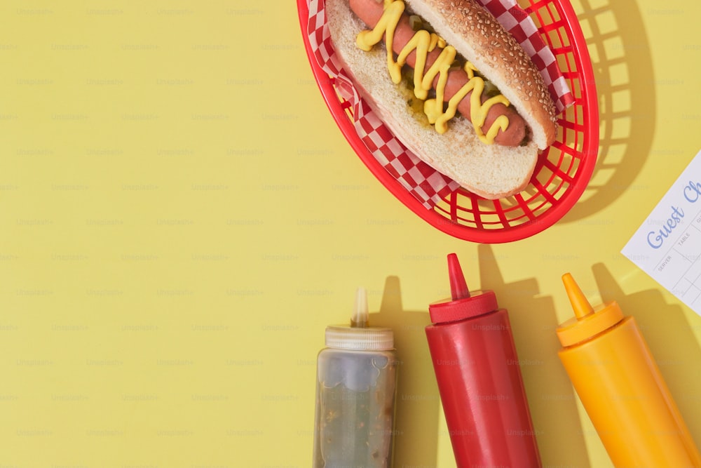a hot dog in a basket with mustard and ketchup