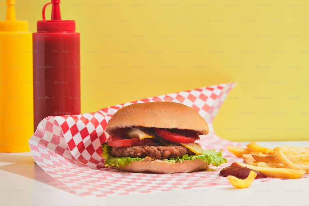 a hamburger sitting on top of a table next to french fries