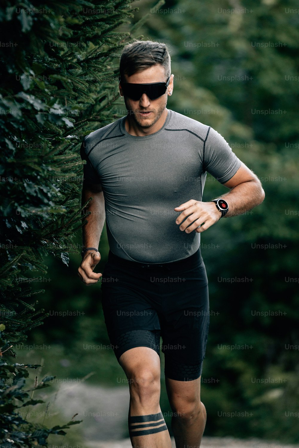a man in a gray shirt and black shorts running