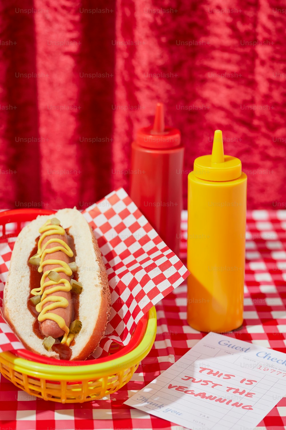a hot dog in a basket with mustard and ketchup