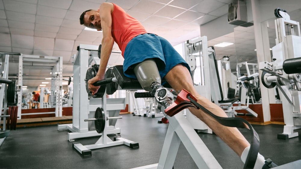 Un hombre está haciendo un press de piernas en un gimnasio