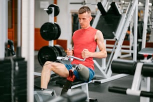 a man sitting on a bench in a gym