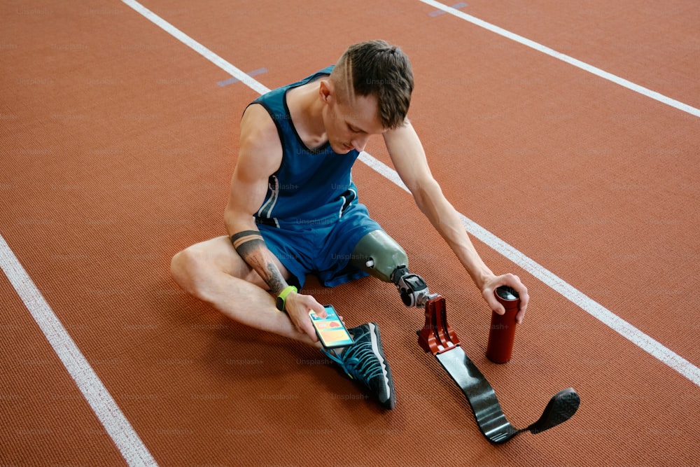 a man sitting on a track tying his shoes