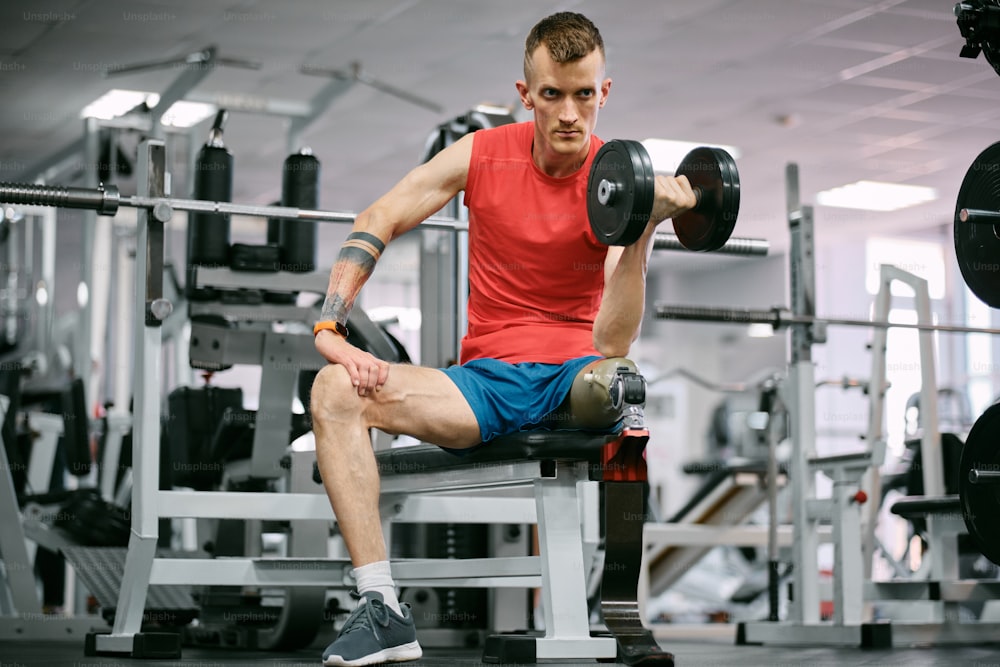 a man sitting on a bench holding a dumbbell