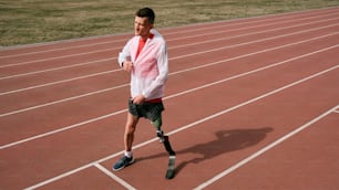 a man with a broken leg walking on a track