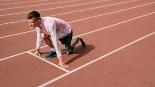 a man kneeling down on a running track