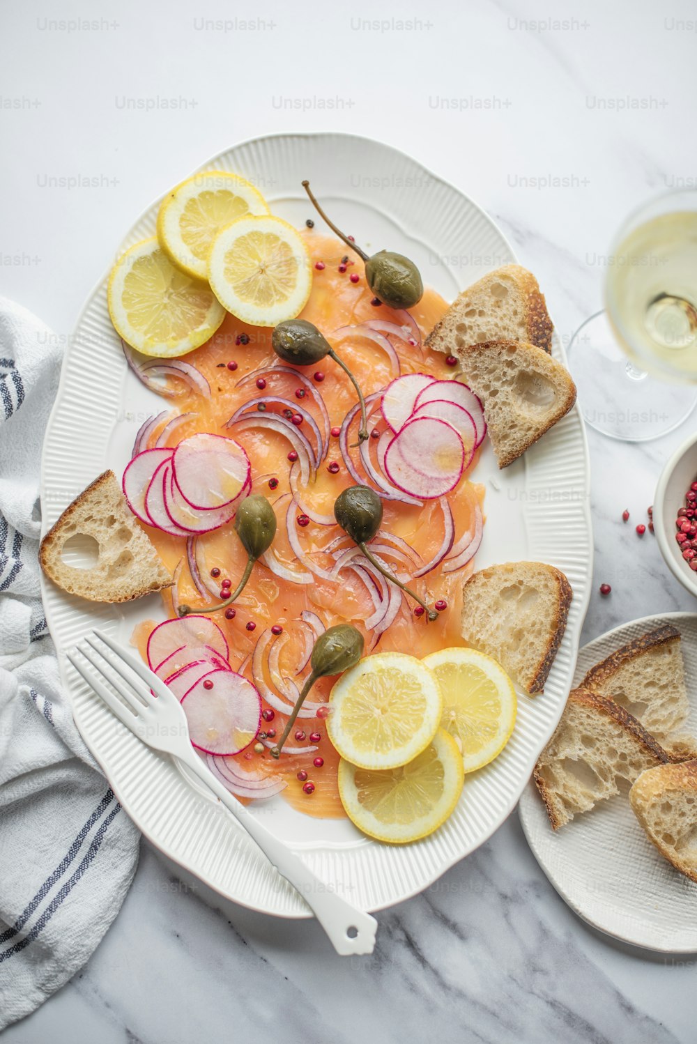 a white plate topped with sliced up lemons and radishes