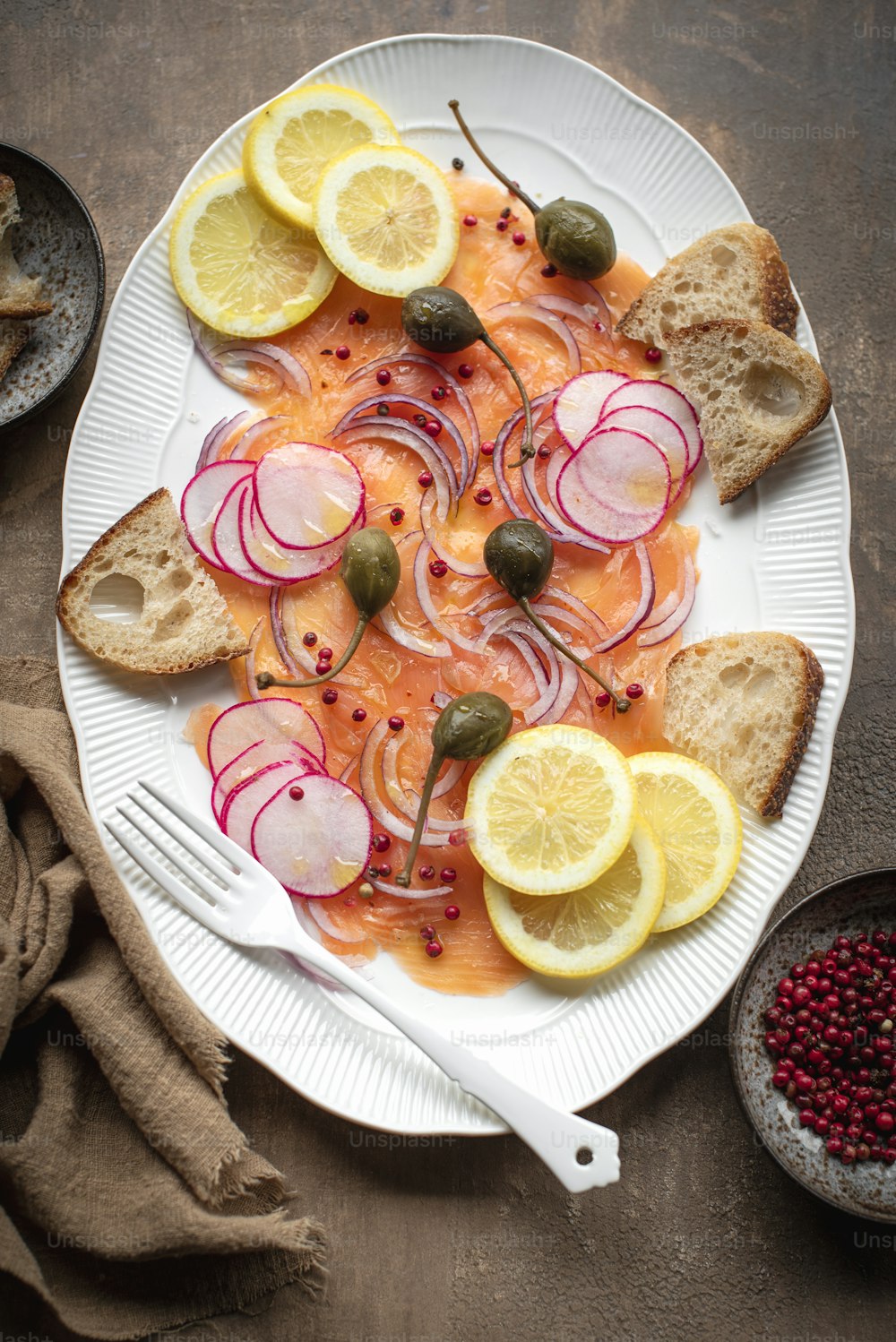 a white plate topped with sliced up lemons and radishes