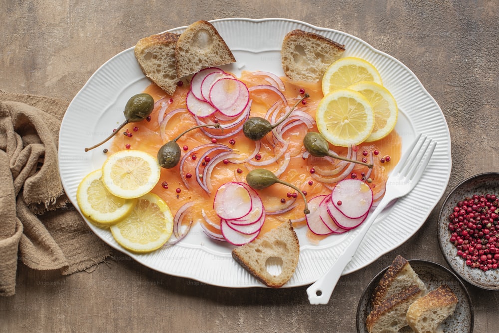 a white plate topped with sliced up lemons and radishes