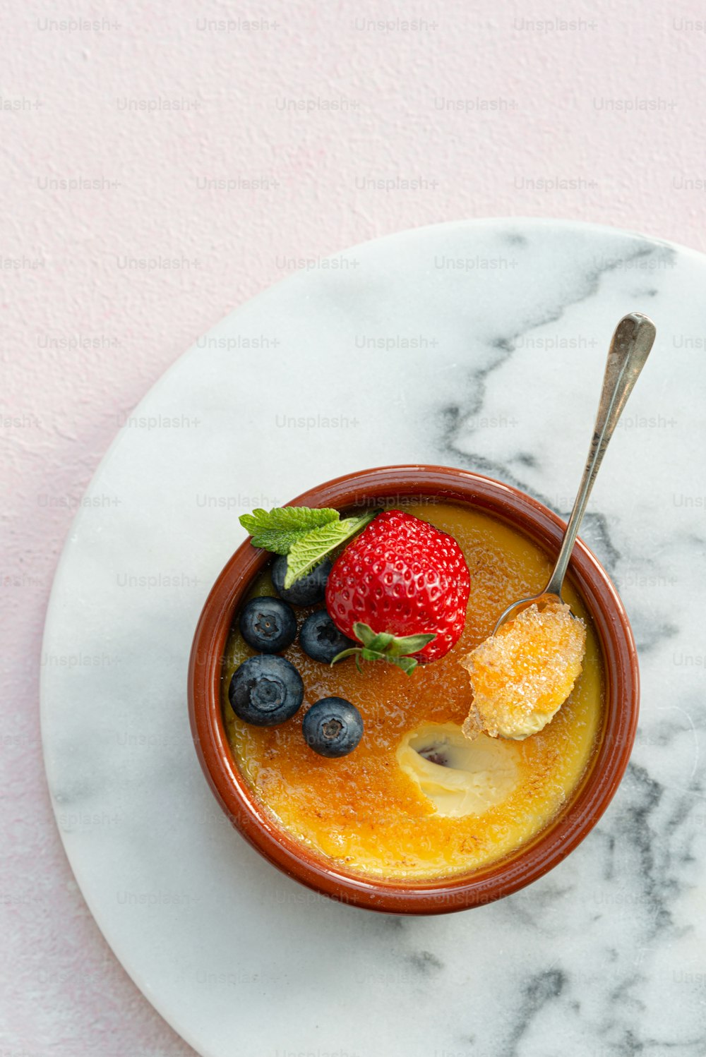 a bowl of fruit is on a marble plate