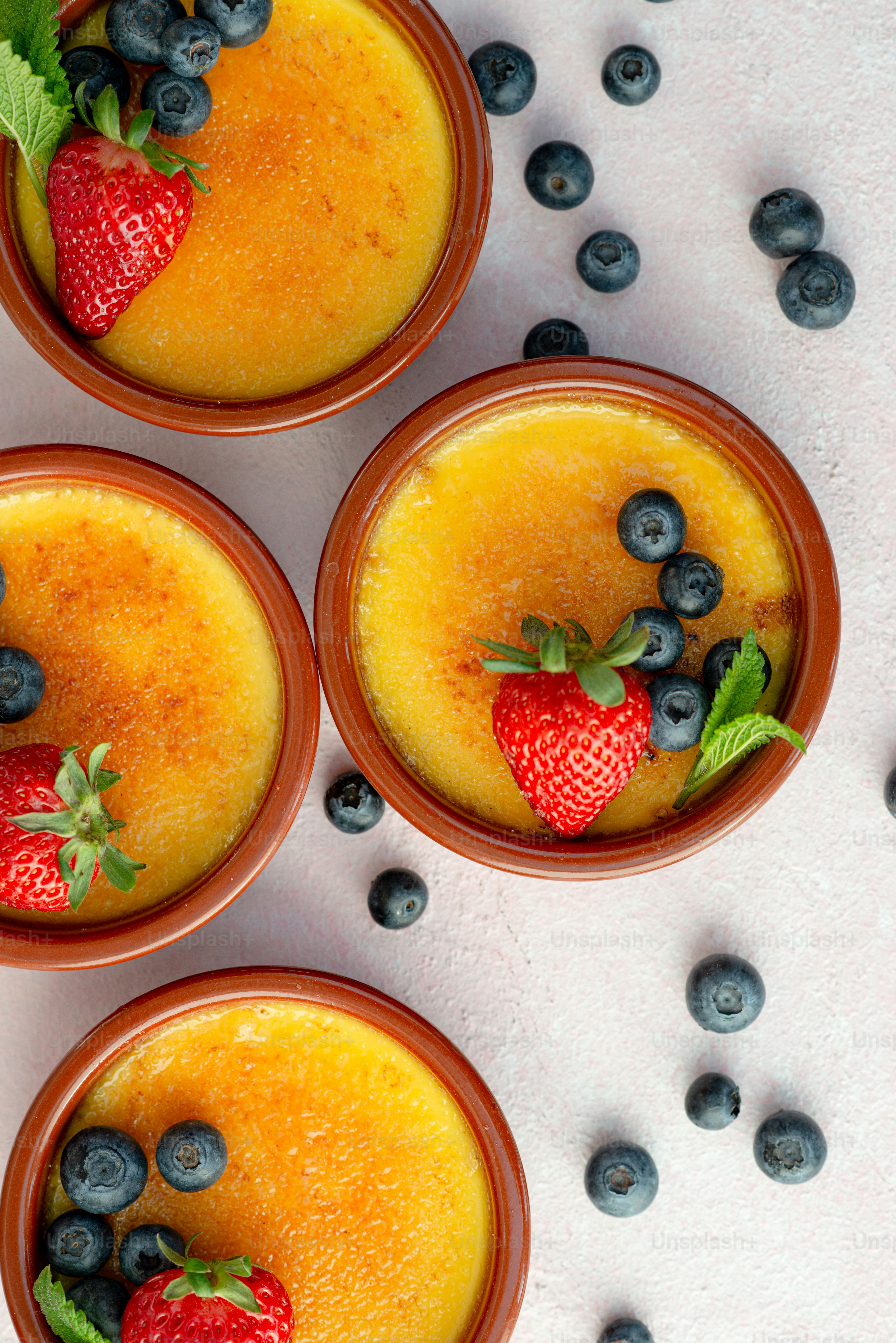 four bowls of food with blueberries and strawberries