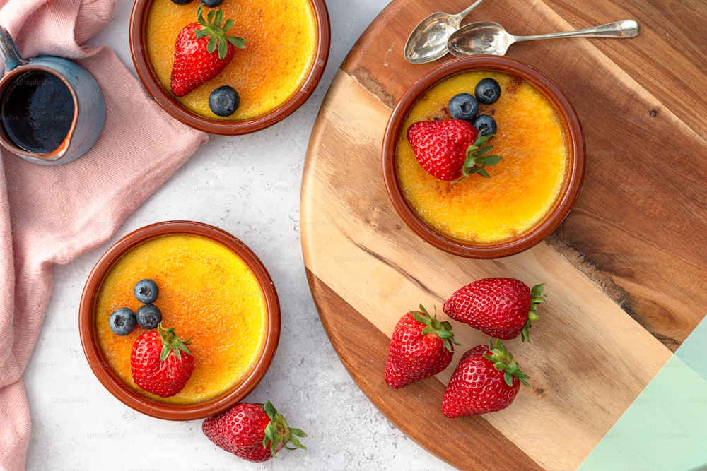 two bowls of pudding with strawberries and blueberries