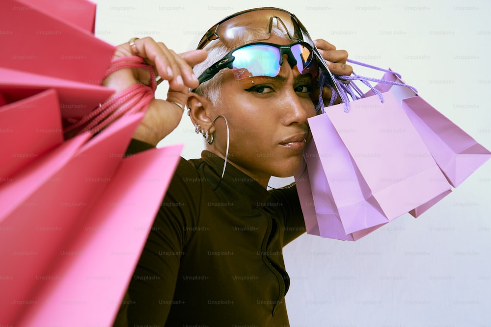 a woman holding shopping bags and a pair of sunglasses