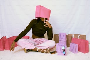 a woman sitting on the floor with a pink paper hat on her head