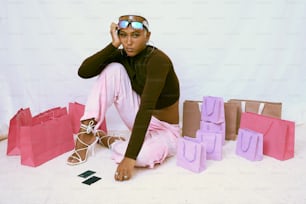 una donna seduta sul pavimento con le borse della spesa