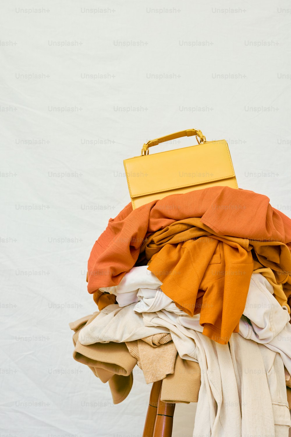 a yellow suitcase sitting on top of a pile of clothes