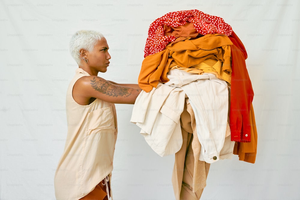 Un hombre de pie junto a una pila de ropa