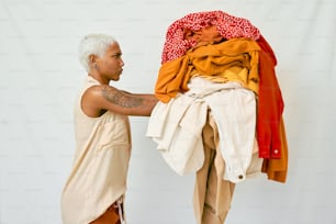 un uomo in piedi accanto a una pila di vestiti