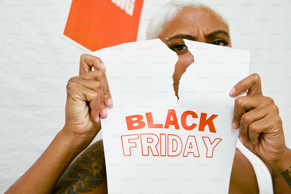 Un hombre sosteniendo un pedazo de papel que dice Black Friday