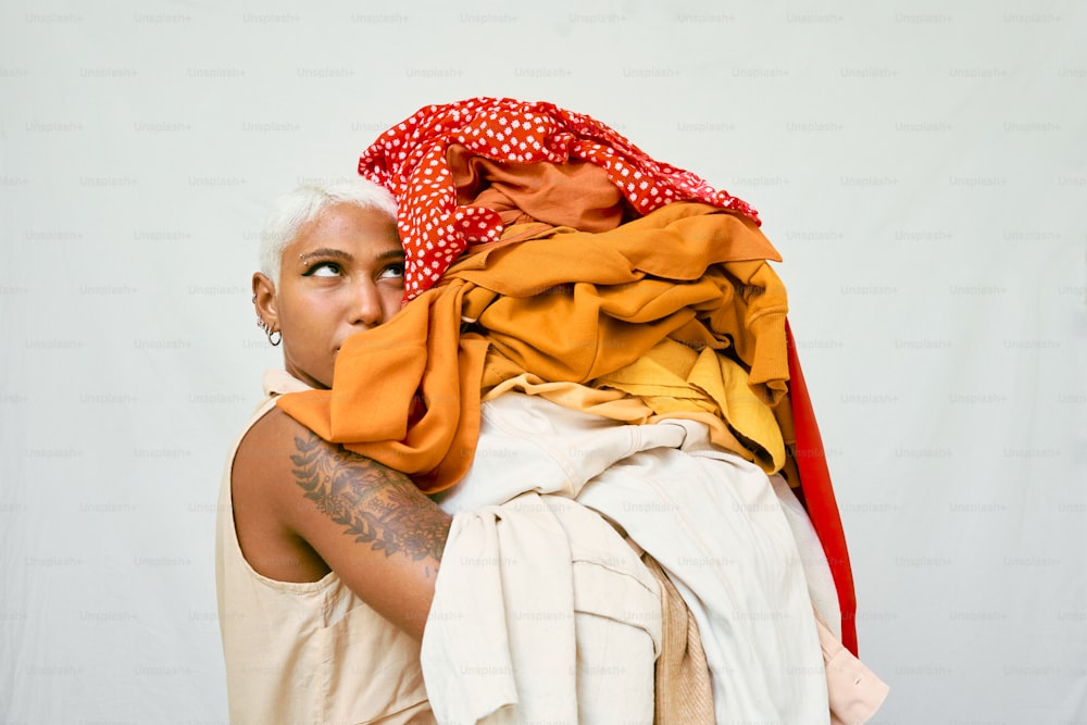 uma mulher com cabelos brancos segurando uma pilha de roupas